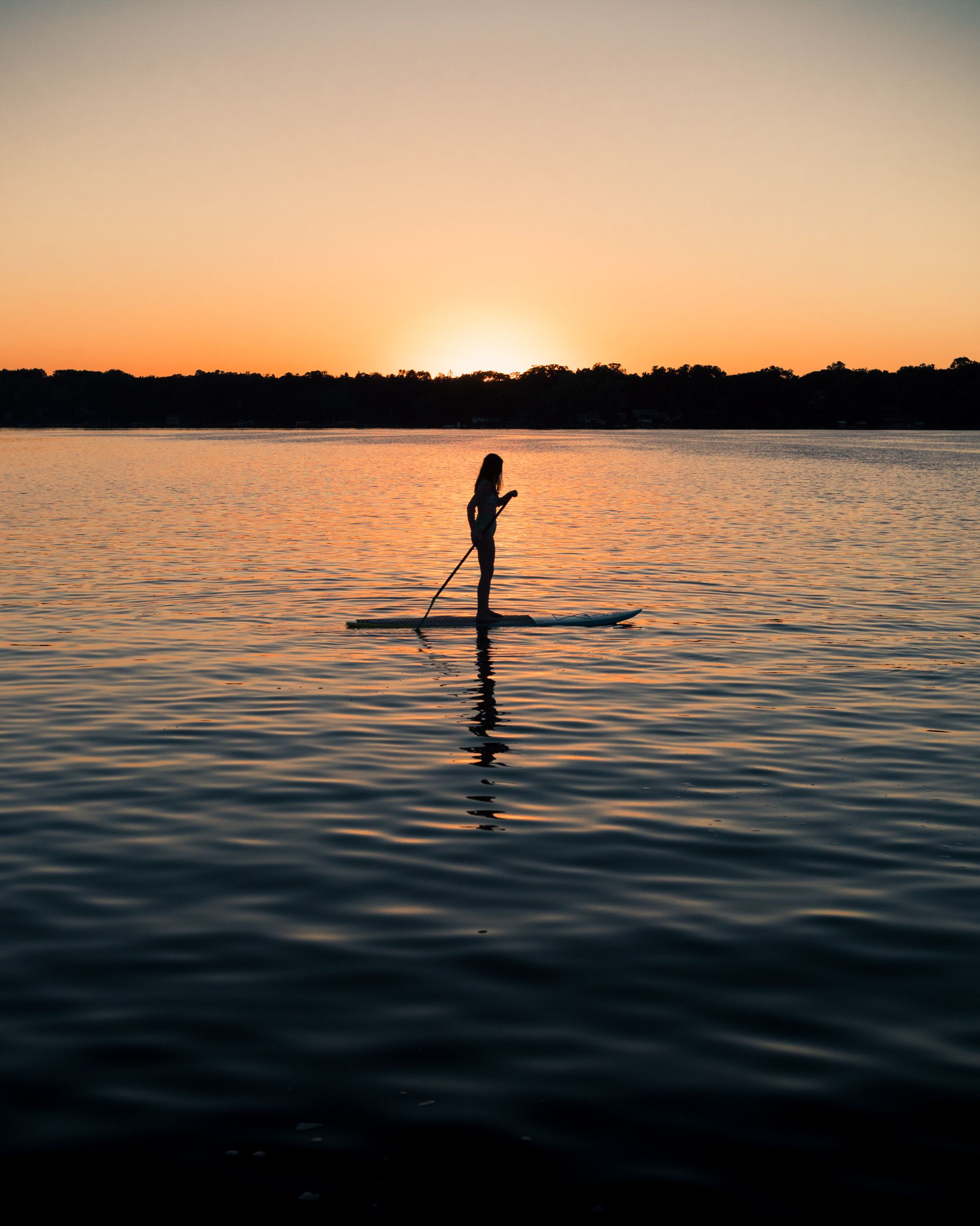Pexels: Photo by Levi Vaagenes: https://www.pexels.com/photo/woman-paddleboarding-on-lake-at-sunset-11504431/