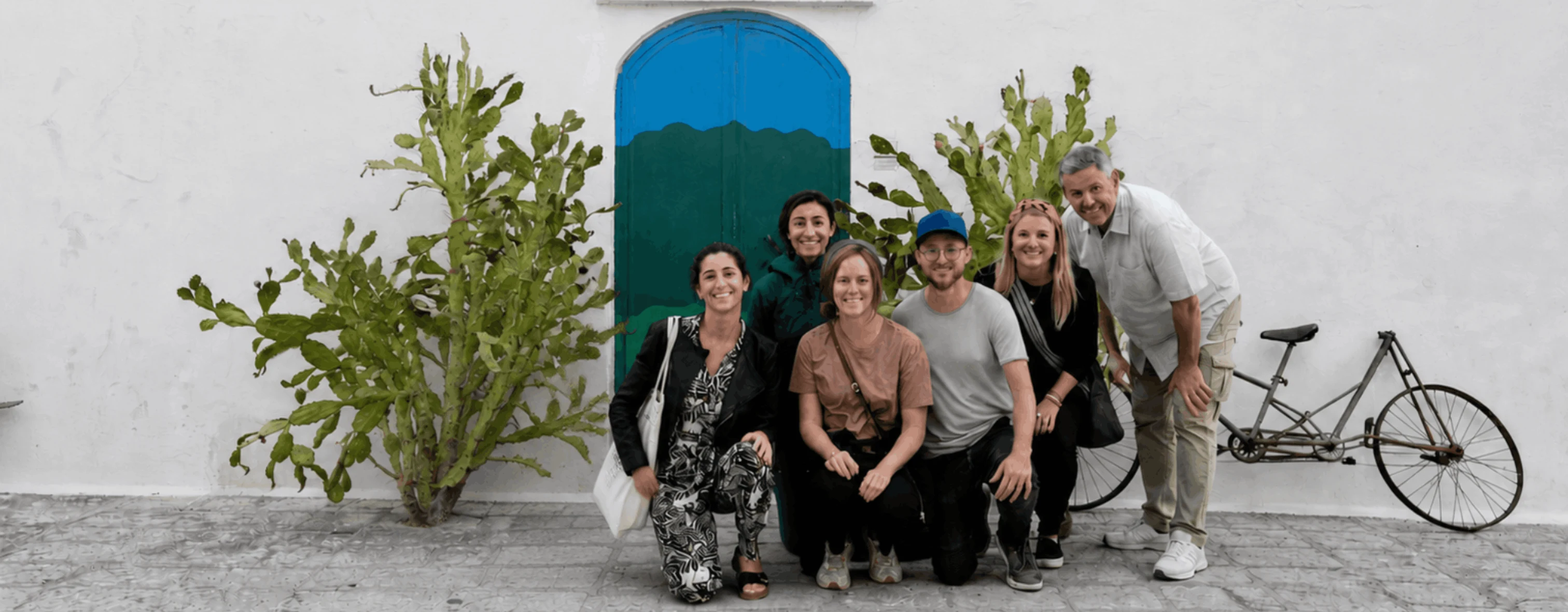 Un gruppo di nomadi digitali sorride davanti alla Porta Blu a Ostuni