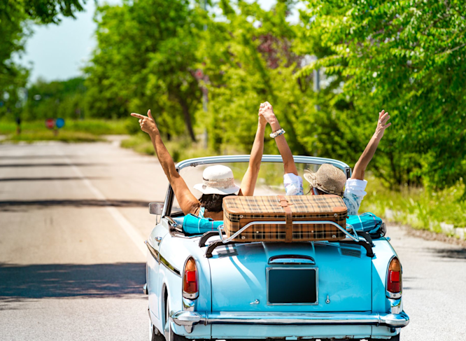 Due amiche gioiscono guidando un'auto vintage durante un viaggio in Italia