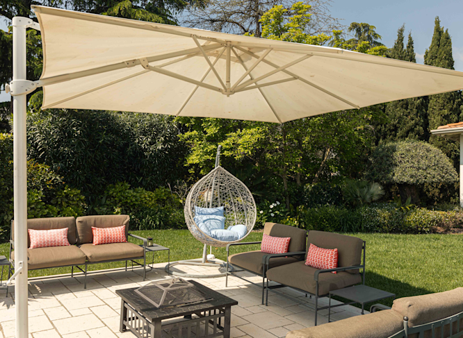 Il giardino privato di una villa sul Lago di Garda con ombrellone, tavolino e poltrone