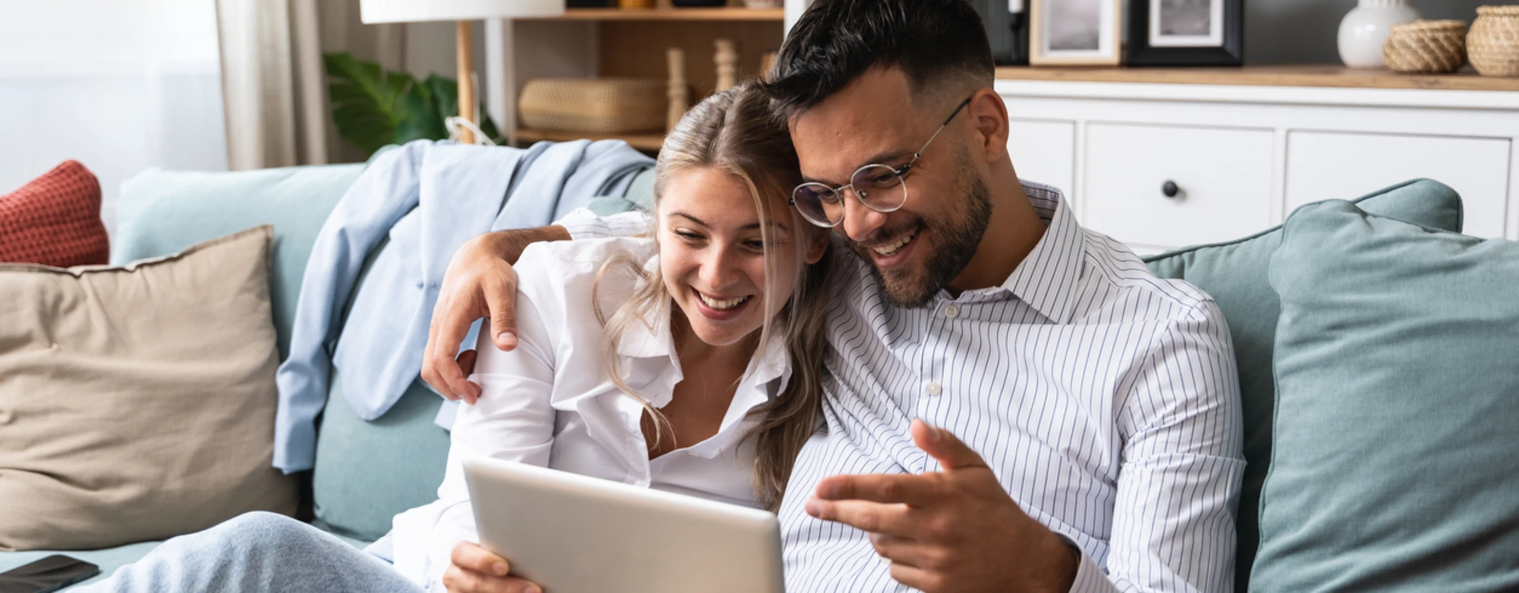 Una coppia sul divano guarda insieme il sito di Wonderful Italy sul proprio tablet