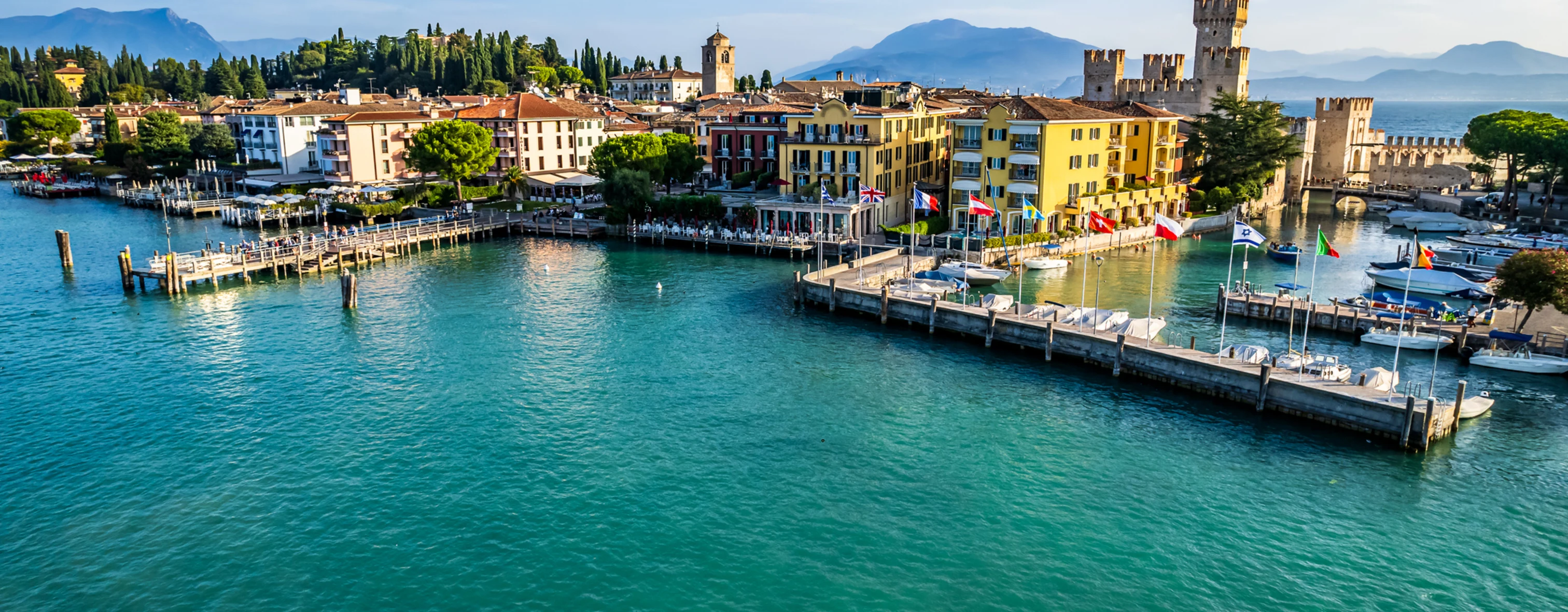 The port of Sirmione seen from above with a boat passing through it
