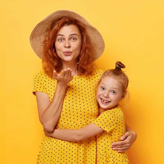 Mom and daughter in matching yellow dresses with yellow background (top block)