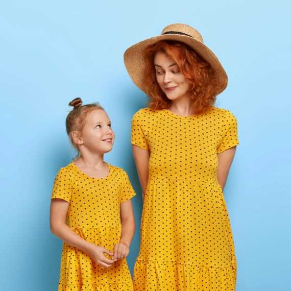 Mom and daughter in matching yellow dresses with blue background (top block)