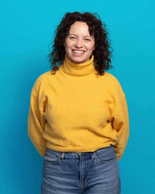 Young woman smiling on blue background (large - 4col)