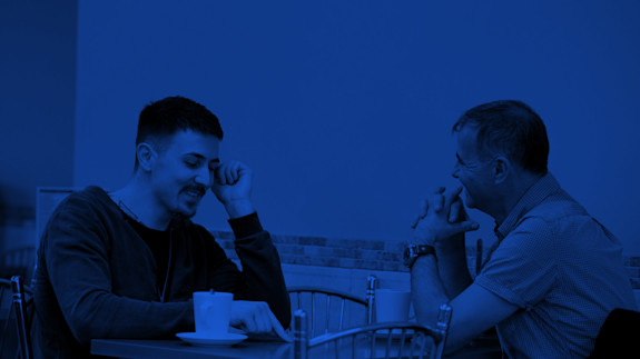 Hero image | Talk to us Two people sat in a coffee shop, deep in conversation