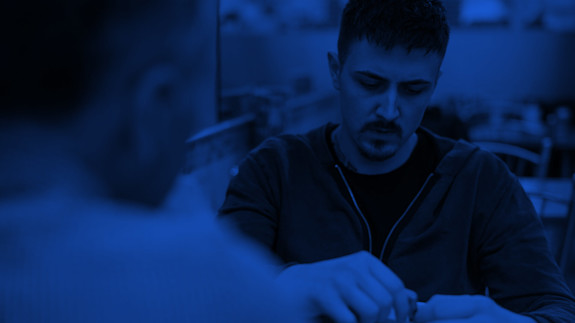 Hero image | How we work Two people sit across from each other, deep in conversation