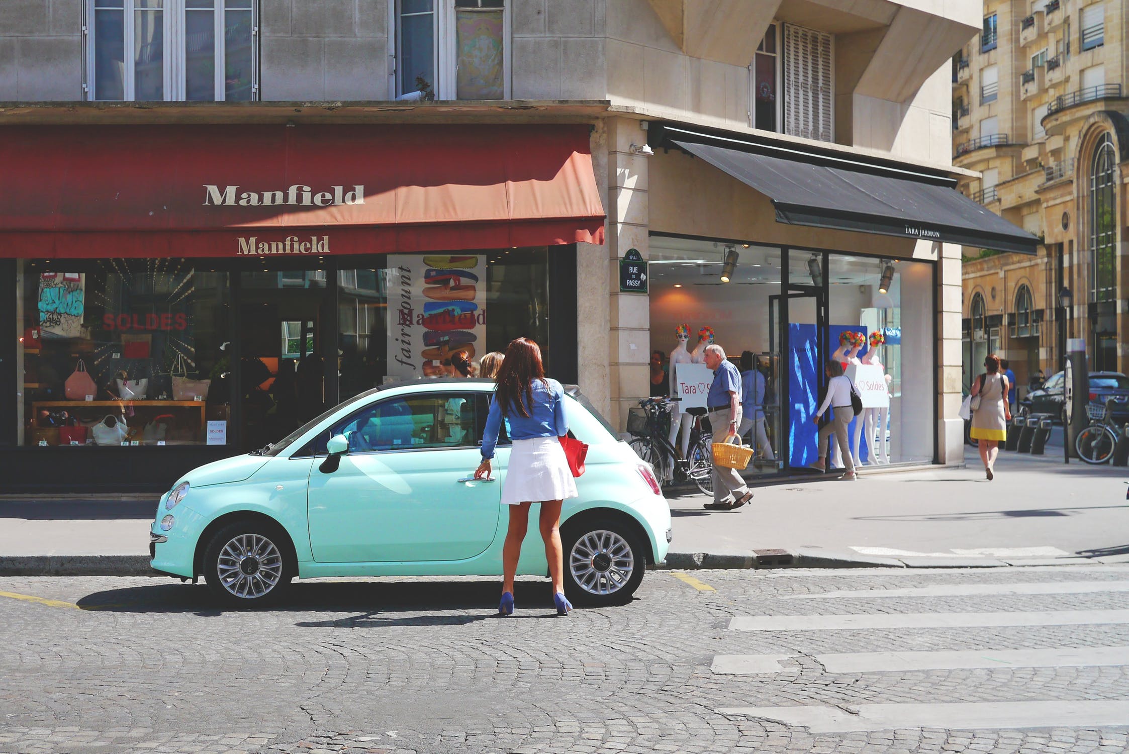 a woman near a green car