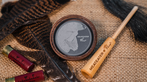 Wooden turkey slate call engraved turkey head with MEATEATER and Phelps; striker labeled MEATEATER, feathers