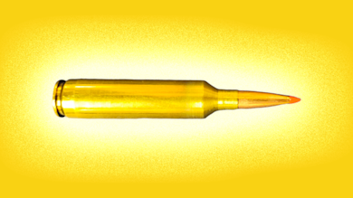 Brass rifle cartridge with orange polymer-tipped bullet