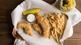 Crispy breaded turkey tenders with ranch dip, fries, and dill pickle spear