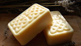 Two pale yellow rectangular soap bars with carved Celtic-knot tops