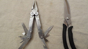 SOG multitool with multiple open blades and a pair of stainless shears with black handles