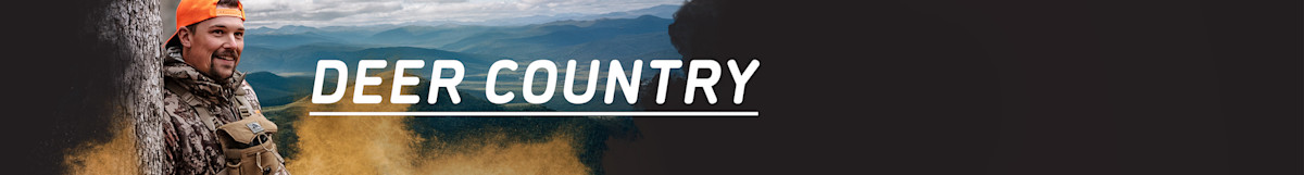 'DEER COUNTRY' text over mountains; smiling hunter in camouflage and orange cap by a tree