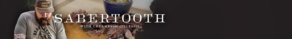 Banner with SABERTOOTH and WITH CHEF KEVIN GILLESPIE text, bearded man in cap and cooked meat