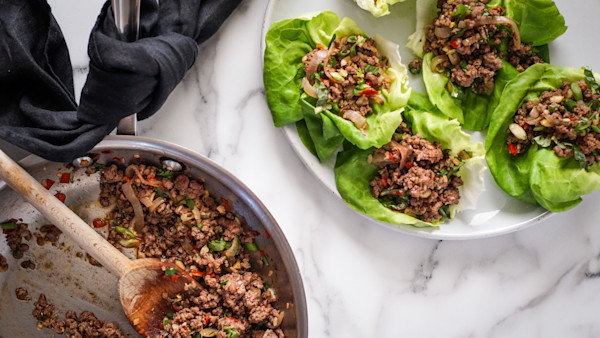 Thai-style venison lettuce cups on plate with cooked minced venison in skillet