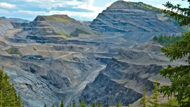 Open-pit mine with terraced benches and tree-lined edges