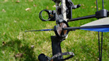 Compound bow with arrow seated in whisker biscuit rest on grass
