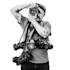 Man with mustache aiming Pentax camera; multiple cameras hang around his neck.