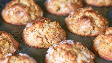 Apple-cider muffins in a dark muffin tin, sugar sprinkled on top