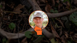 Hunter in camo cap inside orange circle over antlers background, text "WISCONSIN"