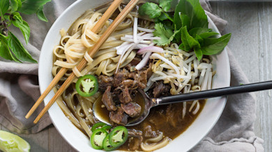 Venison shank pho in bowl with noodles, bean sprouts, basil, sliced jalapeño and chopsticks