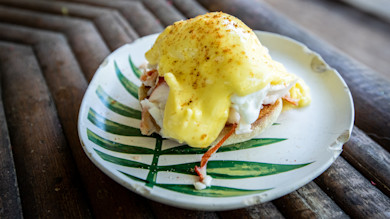 Lobster eggs Benedict with poached egg and hollandaise on leaf-pattern ceramic plate