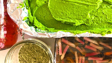 Bright green ramp (wild leek) puree in foil with jarred pickled ramps and green seasoning