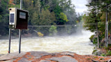Rushing whitewater river with mist and USGS monitoring box on metal poles