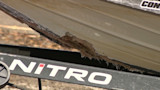 Torn fiberglass along boat hull on trailer, 'NITRO' text visible