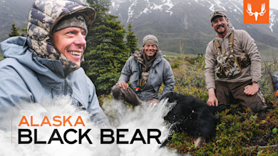 Steven Rinella kneeling with two hunters beside a black bear; overlay text "ALASKA BLACK BEAR"