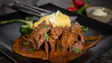 Pulled venison shank in smoky red pepper sauce with grilled jalapeño and polenta