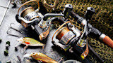 Two spinning reels with lures, treble hooks, sinkers and fishing net