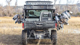 UTV tailgate with many mallard ducks hung on both sides in a grassy field