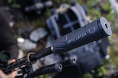 Rifle suppressor engraved with "MEATEATER" and antler logo attached to barrel