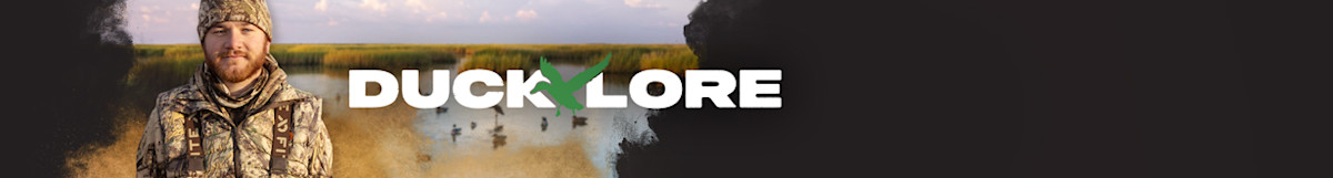 DUCKLORE banner: man in camouflage standing in marsh with ducks on the water