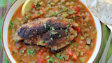 Blackened catfish fillets on creole stew with celery, tomatoes, parsley, lemon wedge and bread