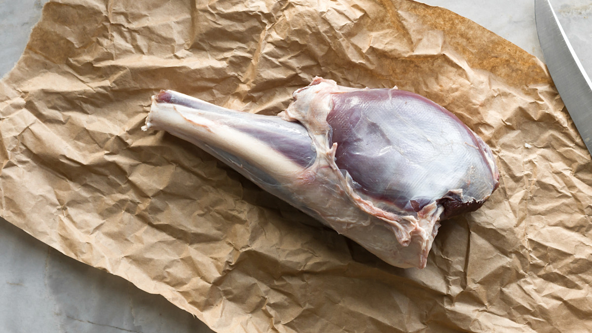 Venison shank with silverskin on crumpled brown butcher paper, knife at edge