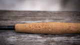 Worn cork fishing rod handle with heavy pitting and gouges