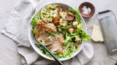 Sliced grilled turkey and pesto pasta salad with farfalle, cherry tomatoes, greens and croutons