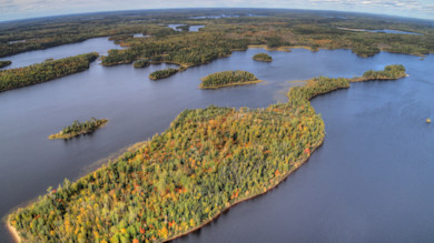 Aerial view of lakes dotted with forested islands and fall foliage
