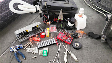 Tools and spare parts on boat deck, Buss fuse box, socket set, pliers, multimeter, tape, bilge pump, toilet paper