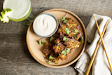 Zucchini fritters with creamy dipping sauce, microgreens, chopsticks, and a green drink
