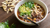 Smoked venison tortilla soup with avocado, cilantro, jalapeño, cotija, and crispy tortilla strips