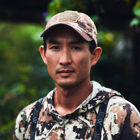 Hunter in camouflage hoodie with First Lite straps and camo cap