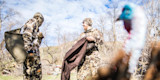 Two hunters in camouflage preparing a turkey vest; blurred turkey head in foreground