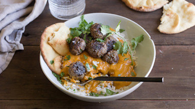 Indian-spiced meatballs over rice with pumpkin curry, cilantro garnish and torn naan