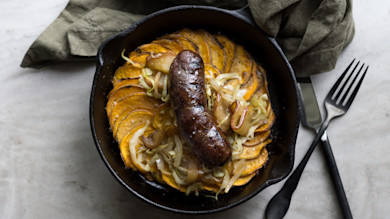 Antelope sausage in cast-iron skillet with roasted sweet potato slices and sautéed cabbage