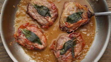 Four venison saltimbocca medallions in skillet with fried sage and pan sauce