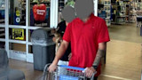 Man pushing shopping cart into store while another person holds a fawn; door sign reads "Grocery Pickup"